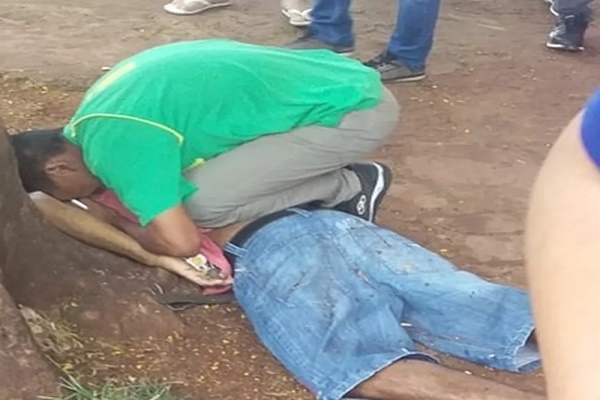 Adolescente chora sobre corpo de pai, que foi executado com tiros de fuzil e pistola, em Pedro Juan Caballero, Paraguai. ? Foto: Léo Veras/Porã News