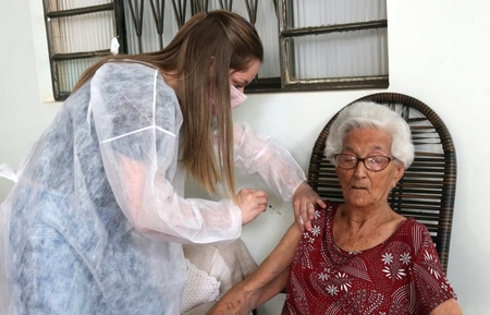 Dona Odete de Almeida, 105 anos, sendo imunizada com a 3ª dose da vacina contra a covid-19. (Foto: Rafael Brites)